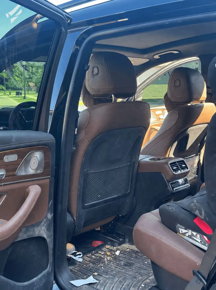 Before: Mercedes-AMG GLS 63 rear cabin with debris on the floor and a dirty child seat